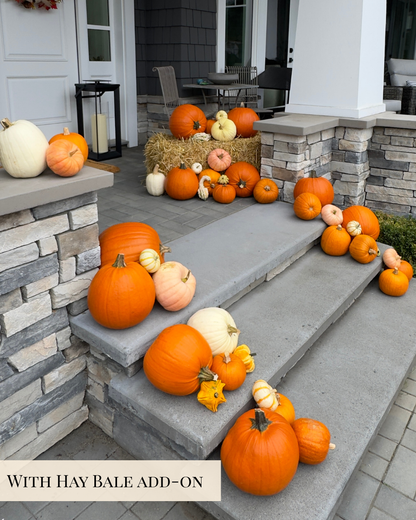 An outdoor front porch and stone steps decorated with many orange, peach, cream, and yellow pumpkins and gourds, including a bale of hay piled with pumpkins. A text banner at the bottom reads “WITH HAY BALE ADD-ON."