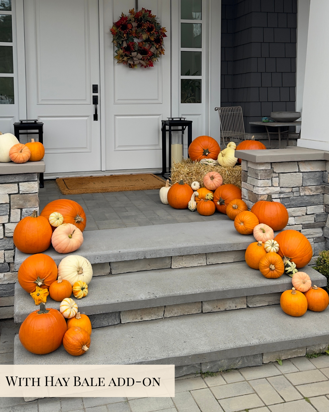 Outdoor front porch decorated with multiple orange and white pumpkins, a hay bale arrangement, and a fall wreath on a white door. A text banner at the bottom reads 'WITH HAY BALE ADD-ON'.