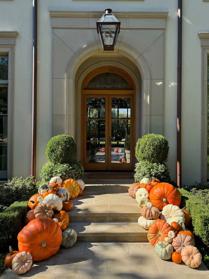 Decorative pumpkins arranged in front of a house entrance