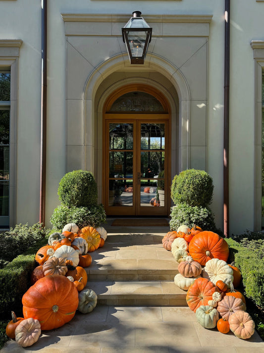 Decorative pumpkins arranged in front of a house entrance