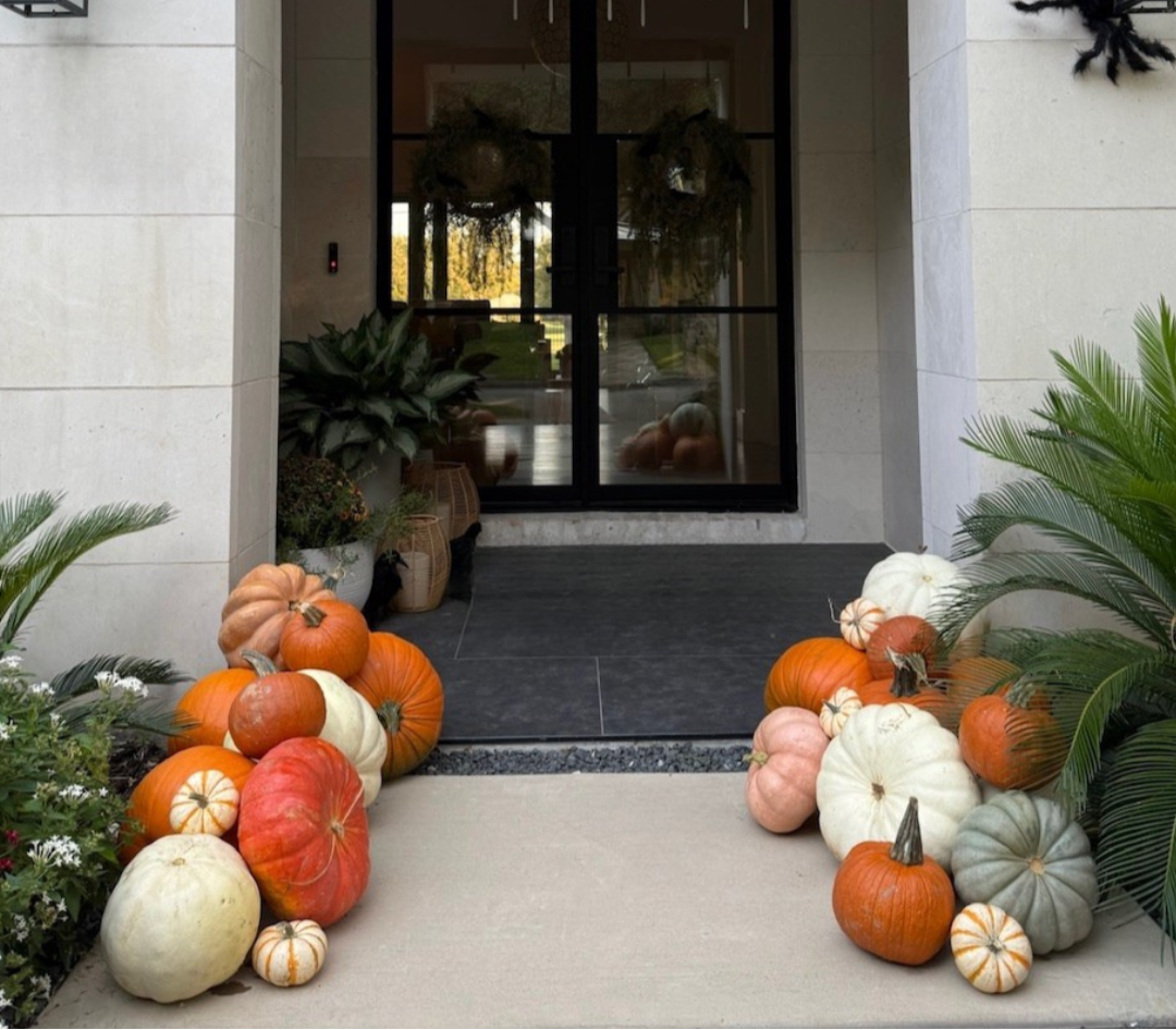 A variety of pumpkins decorate a modern porch.