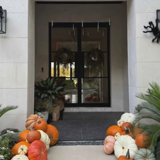 A video of pumpkins of varous sizes, shapes and colours on a porch.