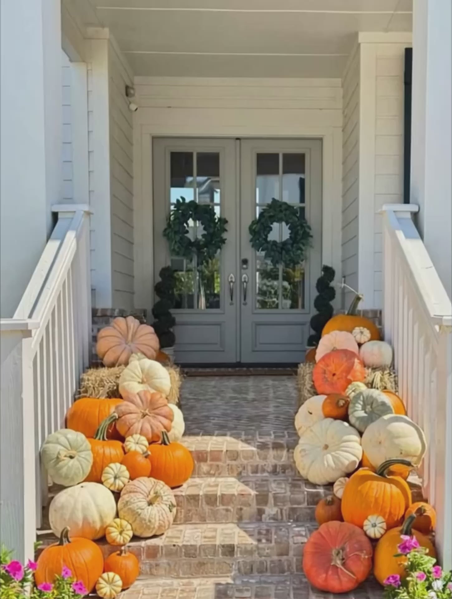 Video of brick porch steps decorated with an abundance of pumpkins. 